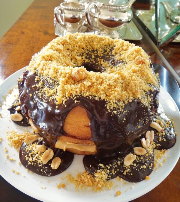 Bolo de amendoim recheado com peanut butter, cobertura de chocolate e praliné de amendoim